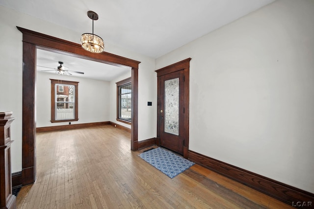 entrance foyer featuring ceiling fan with notable chandelier and hardwood / wood-style floors