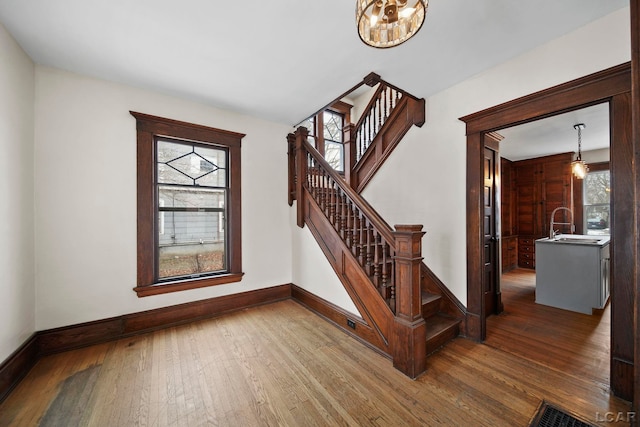 staircase with hardwood / wood-style flooring, plenty of natural light, and sink