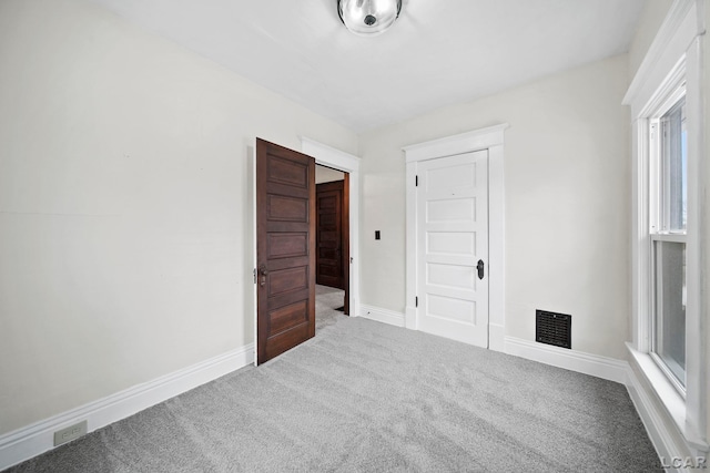 unfurnished room featuring carpet and plenty of natural light