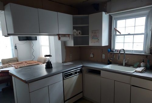 16146 Chapel St, Detroit, MI 48219 - kitchen featuring dishwasher, a sink, light countertops, white cabinets, and a peninsula