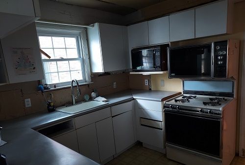 16146 Chapel St, Detroit, MI 48219 - kitchen with gas stove, black microwave, a sink, and white cabinets