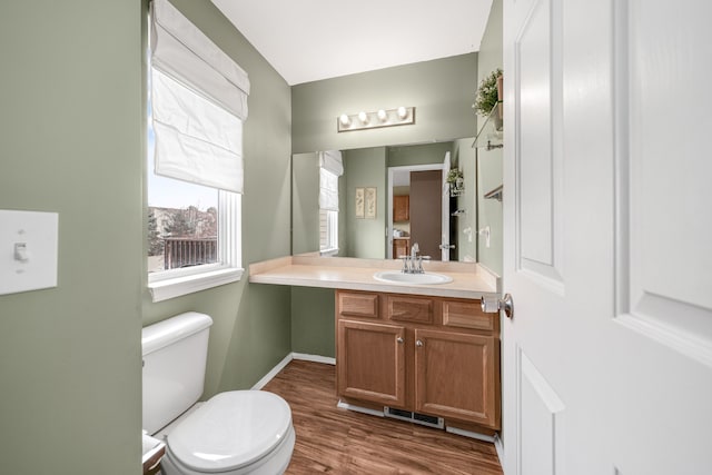 bathroom with vanity, toilet, and wood-type flooring