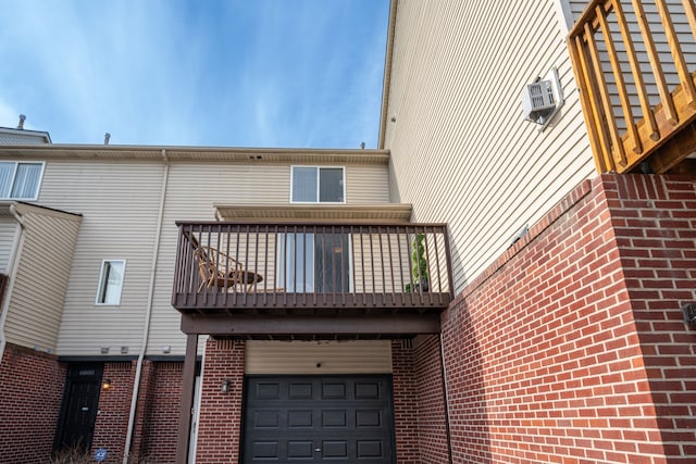 rear view of house featuring a garage and a balcony