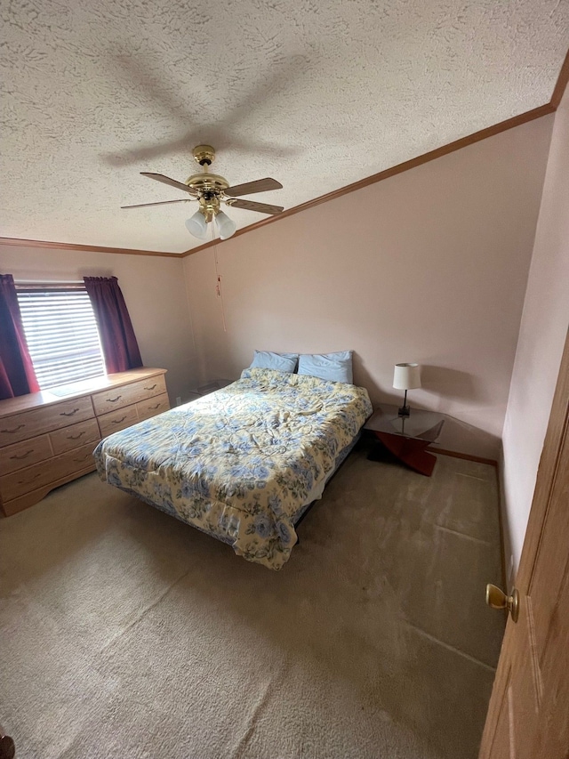 bedroom with ceiling fan, carpet floors, ornamental molding, and a textured ceiling