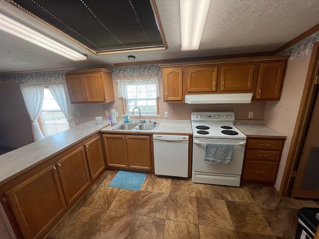 kitchen featuring sink, a textured ceiling, white appliances, and kitchen peninsula