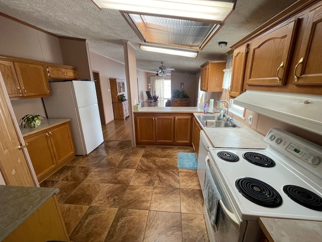 kitchen featuring sink, white appliances, kitchen peninsula, and a textured ceiling