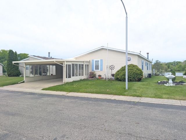 772 Hawick Cir, Mount Morris, MI 48458 - view of front of home with a carport, a front lawn, and central AC