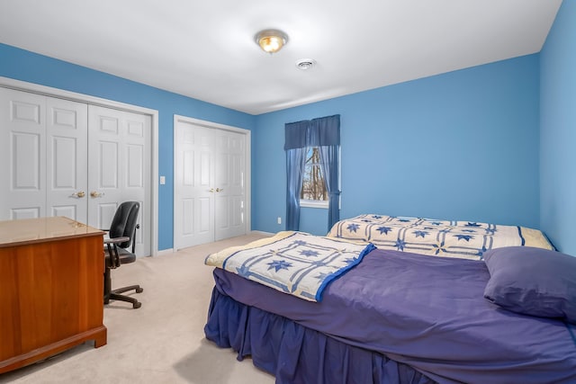 310 Sycamore St, Litchfield, MI 49252 - bedroom with baseboards, visible vents, two closets, and light colored carpet