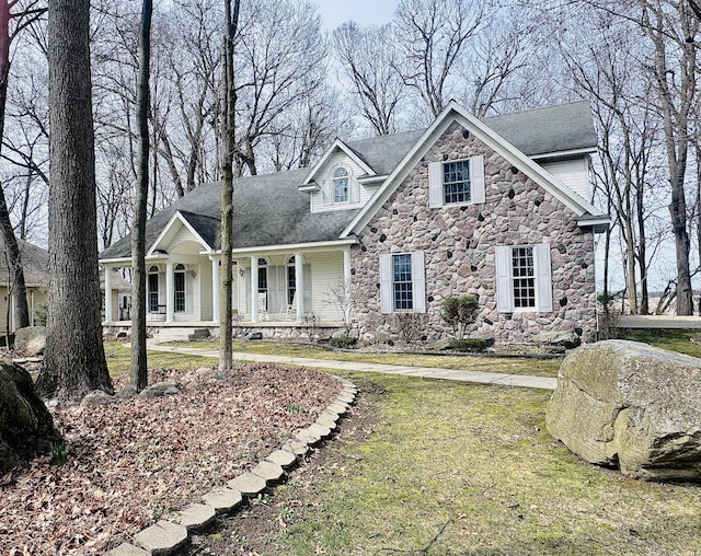 310 Sycamore St, Litchfield, MI 49252 - view of front of house with stone siding, a porch, and a front yard