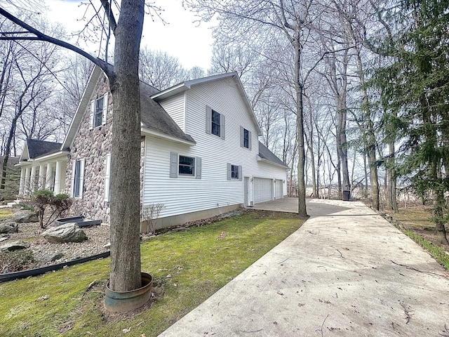 310 Sycamore St, Litchfield, MI 49252 - view of side of home featuring a lawn, driveway, roof with shingles, and an attached garage