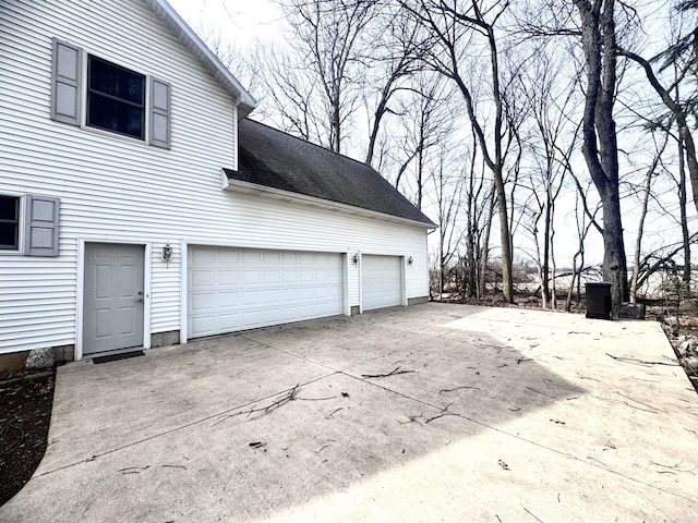 310 Sycamore St, Litchfield, MI 49252 - view of side of property featuring a shingled roof, a garage, and concrete driveway