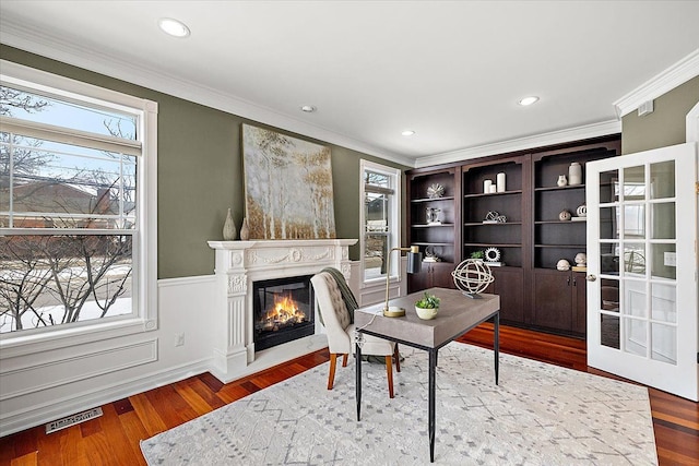 office space featuring wood finished floors, a healthy amount of sunlight, and a premium fireplace