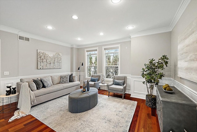 living room with a wainscoted wall, dark wood-type flooring, ornamental molding, and visible vents