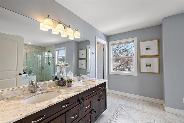 bathroom featuring double vanity, a shower stall, baseboards, and a sink