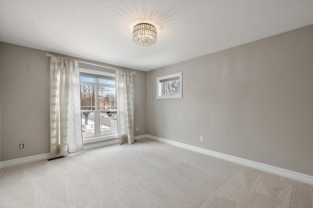 carpeted spare room featuring baseboards