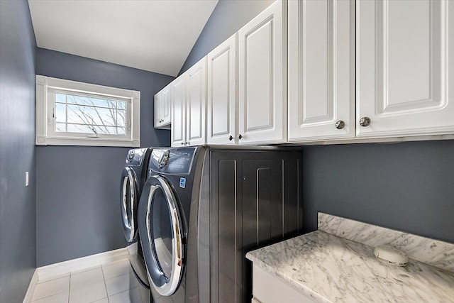 laundry room featuring baseboards, cabinet space, washing machine and clothes dryer, and tile patterned floors