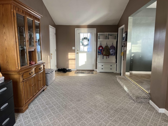 carpeted foyer entrance featuring lofted ceiling