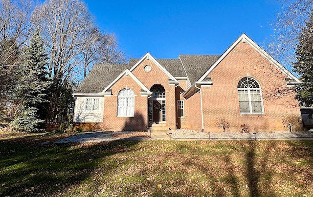 view of front of home featuring a front lawn and brick siding