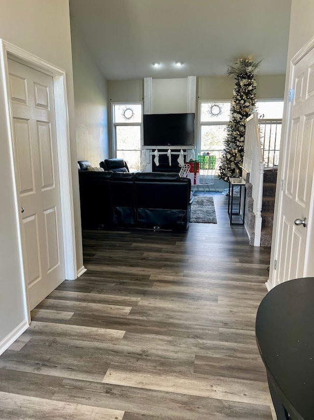 living room with dark wood-style flooring, a healthy amount of sunlight, and stairway