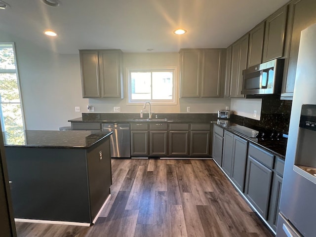 kitchen featuring a sink, appliances with stainless steel finishes, dark wood-type flooring, and gray cabinets