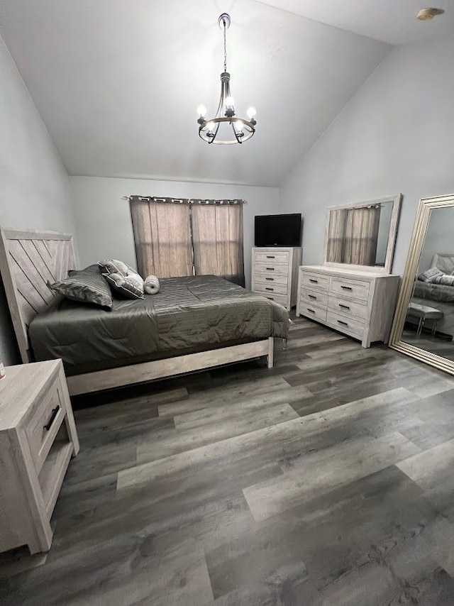 bedroom featuring vaulted ceiling, dark wood finished floors, and an inviting chandelier