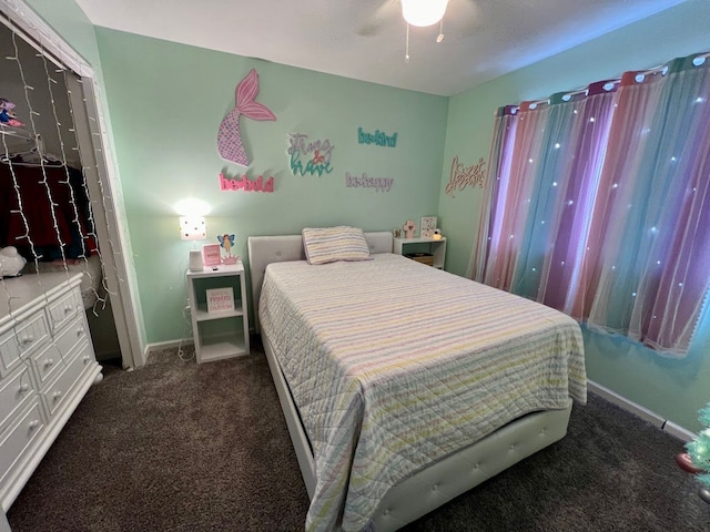 bedroom featuring a ceiling fan, dark colored carpet, and baseboards