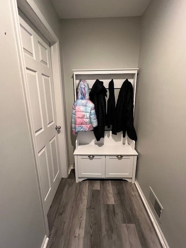 mudroom featuring dark wood-type flooring, visible vents, and baseboards