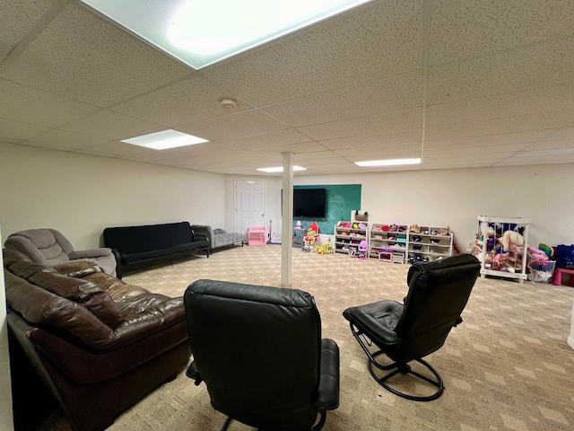 carpeted living room featuring a drop ceiling