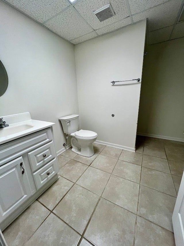 bathroom with toilet, visible vents, a drop ceiling, and tile patterned floors