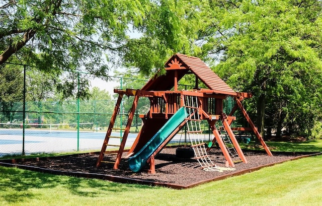 community play area with a tennis court and fence