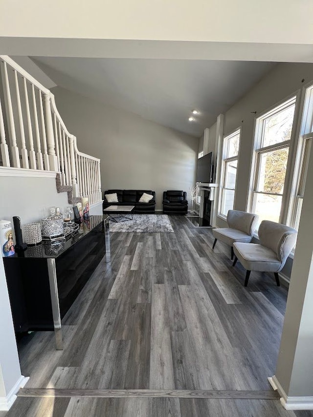 living area featuring stairs, baseboards, and wood finished floors