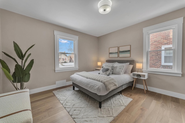 bedroom featuring light wood-type flooring and multiple windows