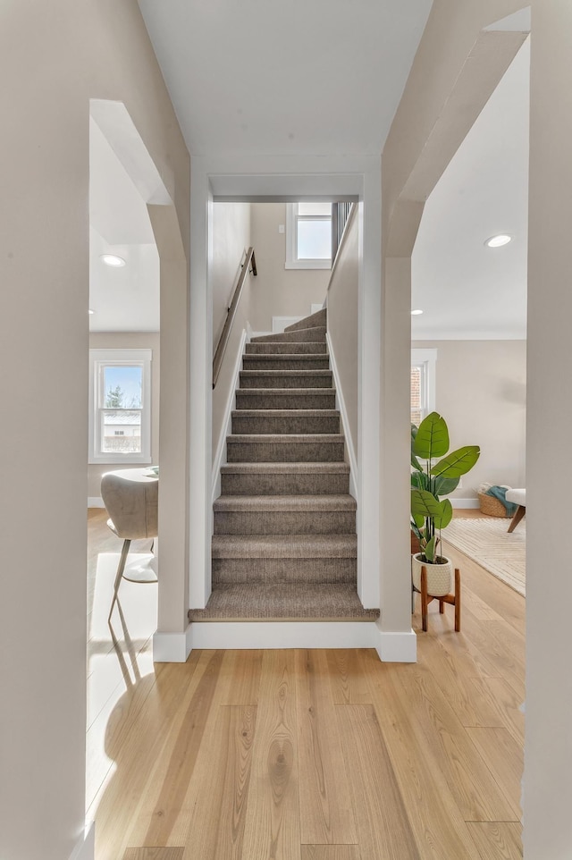 stairway with a healthy amount of sunlight and wood-type flooring