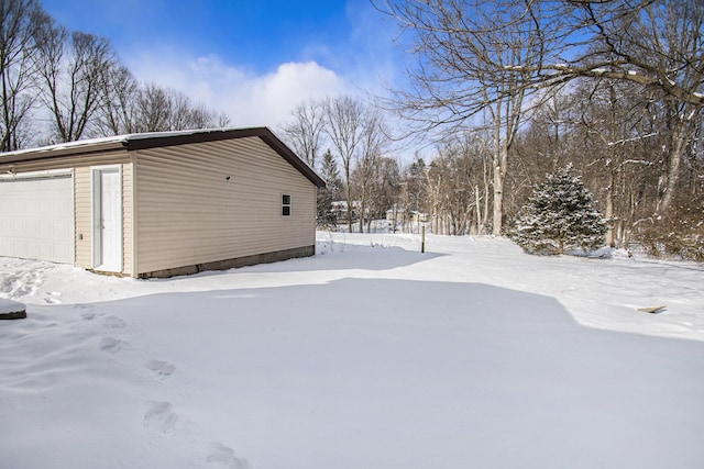 view of snowy exterior with a garage