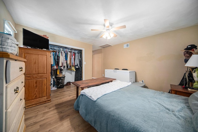 bedroom with a closet, light hardwood / wood-style floors, and ceiling fan