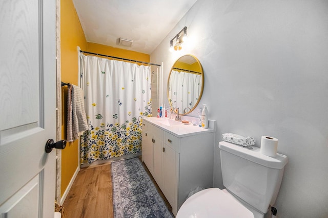 bathroom with toilet, vanity, a shower with curtain, and hardwood / wood-style floors