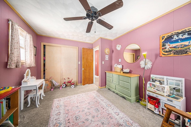 playroom featuring ceiling fan, carpet, and crown molding