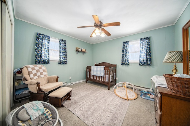 bedroom with ceiling fan, carpet flooring, crown molding, and a crib