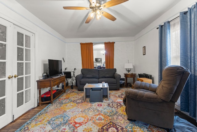 living room with ceiling fan, brick wall, dark hardwood / wood-style flooring, and french doors