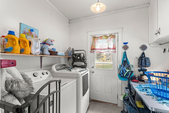 laundry area featuring cabinets, crown molding, and washing machine and clothes dryer