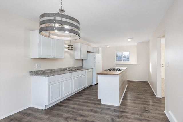 kitchen with hanging light fixtures, white cabinets, wooden counters, and white appliances