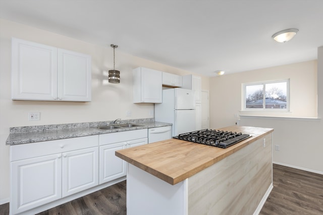 kitchen featuring white appliances, white cabinetry, a kitchen island, pendant lighting, and butcher block countertops