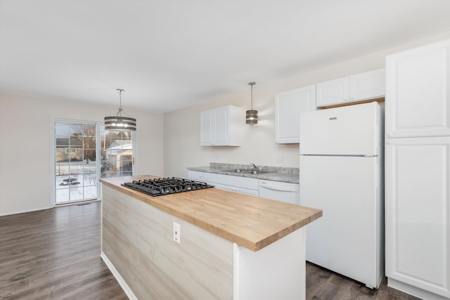 kitchen featuring pendant lighting, sink, white cabinets, white appliances, and a center island