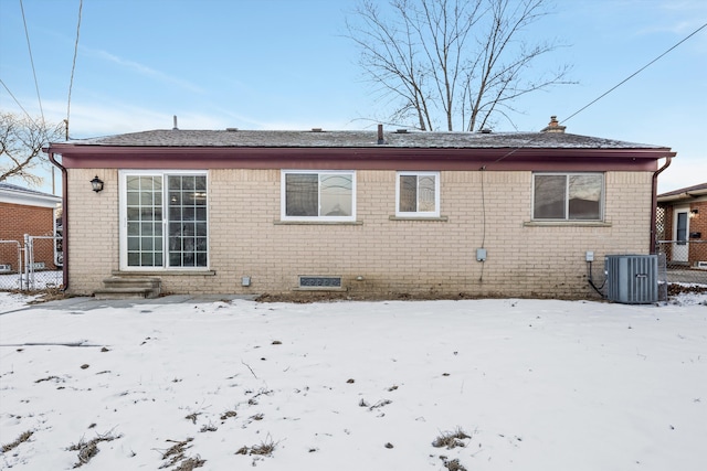 snow covered house featuring cooling unit