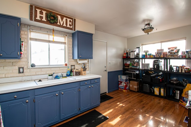 kitchen featuring sink, blue cabinets, a healthy amount of sunlight, and dark hardwood / wood-style floors