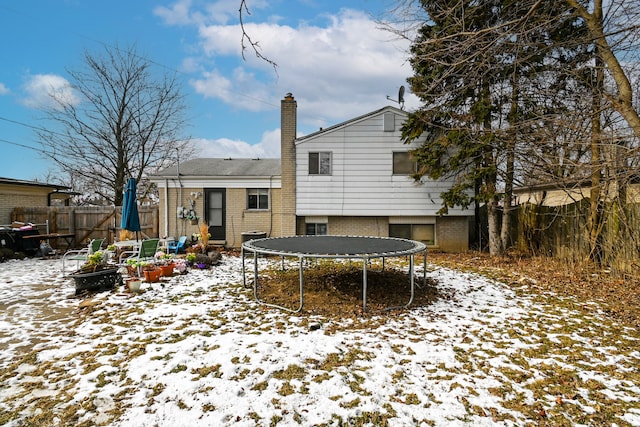 snow covered house featuring a trampoline