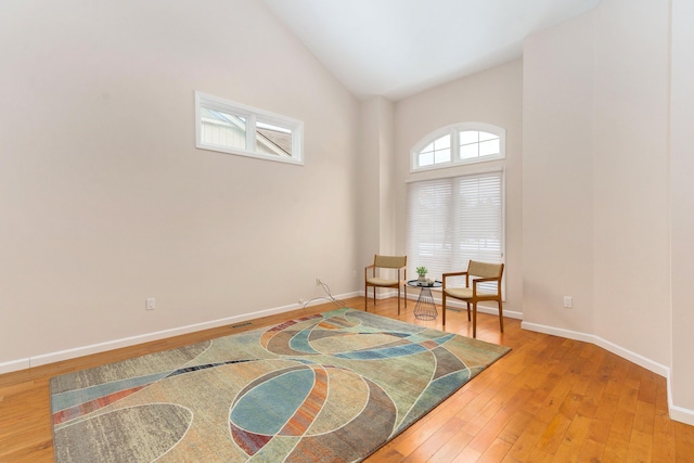 sitting room featuring hardwood / wood-style flooring and high vaulted ceiling