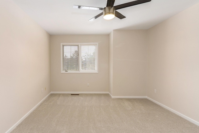 empty room with ceiling fan and light carpet