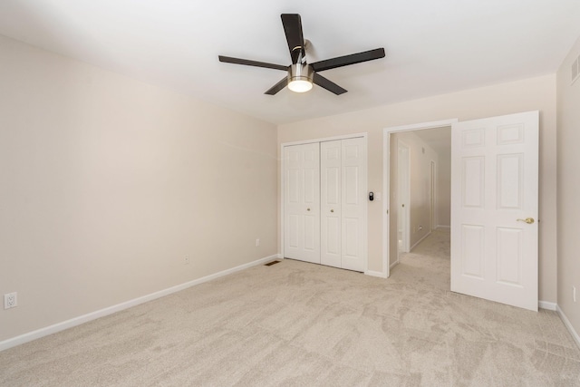 unfurnished bedroom with ceiling fan, a closet, and light carpet