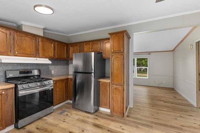 kitchen with appliances with stainless steel finishes, ornamental molding, light hardwood / wood-style flooring, and backsplash